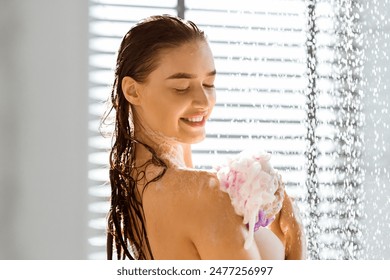 Shower concept. Beautiful woman rubbing body with sponge, standing under water jet - Powered by Shutterstock