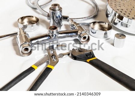 shower faucet details and adjustable wrenches on white ceramic shower tray