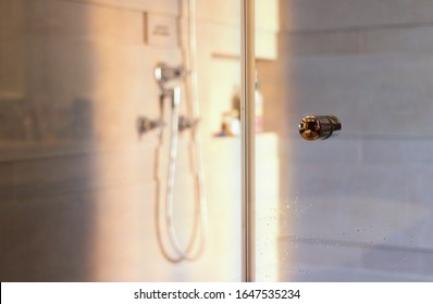 Shower Glass Enclosure With Knob On Blor Sun Light And Bath Room Background In Morning