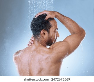 Shower, hair care and man in studio with water splash for hygiene, grooming or shampoo on blue background. Back, body and Asian model washing for natural treatment, wellness or morning routine - Powered by Shutterstock