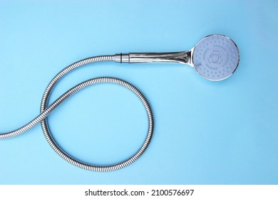 The shower head chrome coated multi-mode for the bathroom with hose on blue background. Top view - Shutterstock ID 2100576697