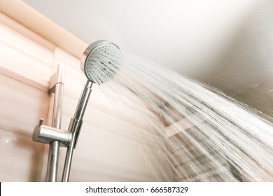 Shower Head With Refreshing Water Droplets Spraying Down In Bathroom