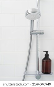 Shower Rack With Hanging Shower Head And Shelf With Bottle Of Gel.