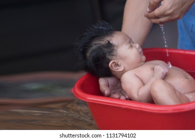 Shower Time. Baby Shower In Asia First Asian Man To Shower For His First Daughter. Asian Children Bath In A Red Casket