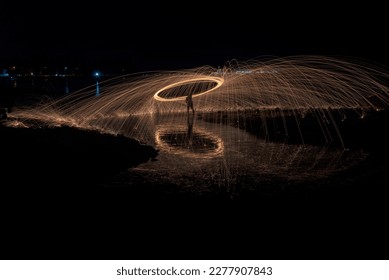 Showers of hot glowing sparks from spinning steel wool. 