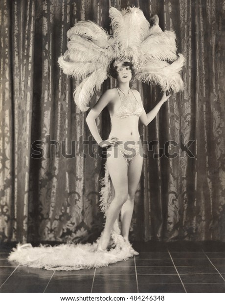 Showgirl\
wearing feather headdress and sequined\
bikini