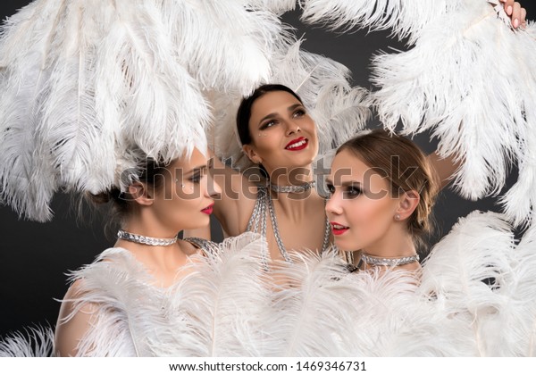 Showgirls with white\
feather fans portrait