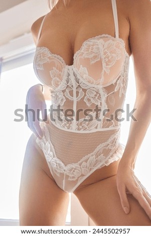 Showing body. Beautiful woman in underwear is posing indoors.