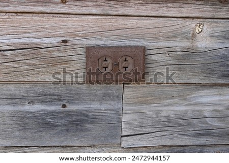 Showing a corroded old outside two prong outlet background.