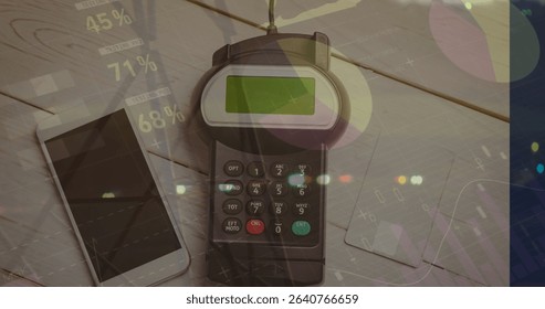 Showing credit card payment terminal processing payment on desk, with smartphone and two credit cards. Technology, fintech, digital, transaction, commerce, business, data visualization
