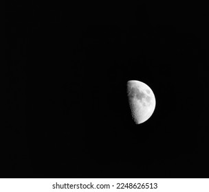 Showing a detailed section of the moon and one half shaded. - Powered by Shutterstock