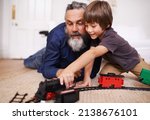 Showing grandpa my new train set. Shot of a grandfather playing with toy trains with his grandson.