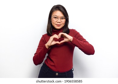 Showing Heart or Love Expression Sign of Young beautiful asian women dress red shirt isolated on white background