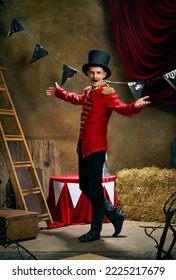 Showman. Vintage portrait of male retro circus entertainer expresses rejoice and announces start of show over dark retro circus backstage background. Concept of emotions, art, fashion, style - Shutterstock ID 2225217679