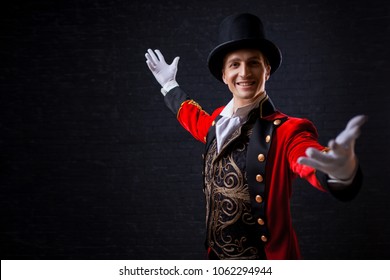 Showman. Young male entertainer, presenter or actor on stage. The guy in the red camisole and the cylinder. Bright tailcoat, suit