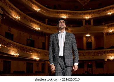 Showman. Young Male Entertainer, Presenter Or Actor On Stage. Male Public Speaker Speaking At Microphone, Performing Presentation On Stage, Looking At Audience. Guy In Classic Formal Wear