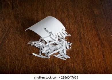 Shred Of Morality Concept Shows The Word ‘Morality’ Recovered From A Pile Of Strip-cut Shredded Paper. The Partially Shredded Page With Word Morality Is Part Of A Pile On Top Of A Rustic Wooden Table.