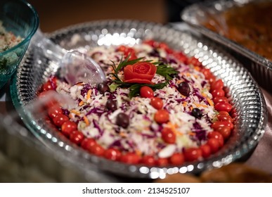 Shredded Carrots, Green And Red Cabbage Salad Decorated With Olives And Cherry Tomatoes Served In Silver Colored Plate For Catering Of An Event