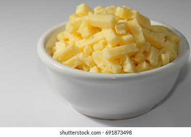 Shredded Cheddar Cheese In Small White Bowl