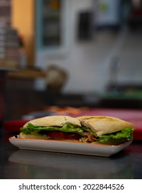 Shredded Chicken Sandwich With Lettuce, Onion And Tomato On The Bar Of A Cafeteria
