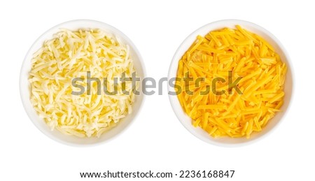 Shredded mozzarella and cheddar cheese, in white bowls. Grated low-moisture mozzarella, and piquant, orange colored natural cheese, both made of pasteurized cow milk. Used for pizza and pasta dishes.