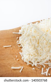 Shredded Mozzarella Cheese On Wood Cutting Board