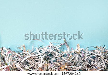Shredded paper on light blue background. Selective focus image.