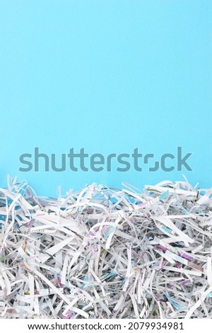 Shredded paper on light blue background. Selective focus image.