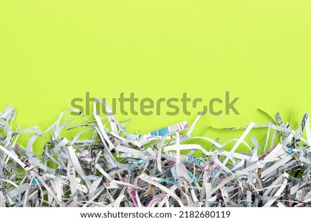 Shredded paper on light green background. Selective focus image.