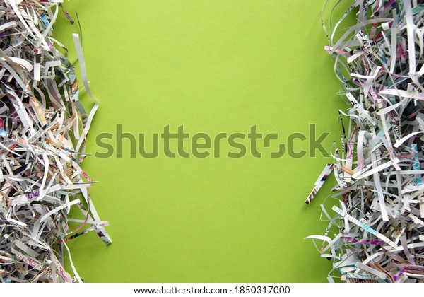 Shredded paper on light green background.\
Selective focus image.