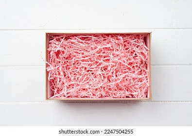 Shredded pink paper packing material in craft gift box. Pink spaghetti shredded packing paper used to protect fragile object while in transport. Mockup design for valentine gift box - Powered by Shutterstock