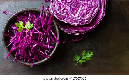 Shredded red cabbage in clay bowl on black background. Vegetarian healthy food. Top view - Powered by Shutterstock