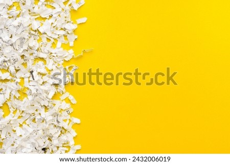 Shredded white paper on light yellow background