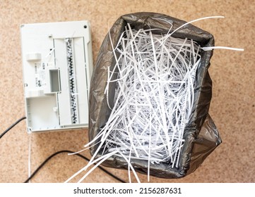 shredder basket filled with cut paper, destruction of confidential information