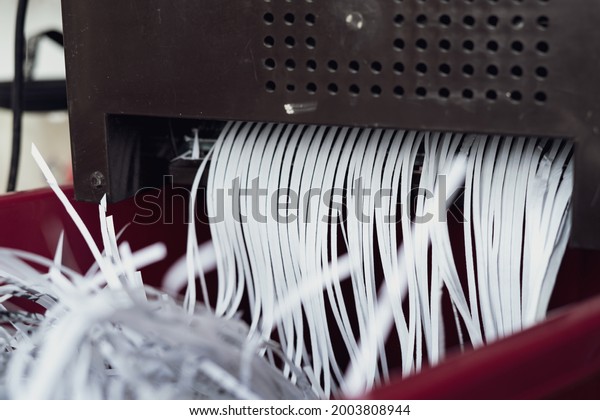 Shredding papers coming out from the machine.\
Shredding documents for\
security.
