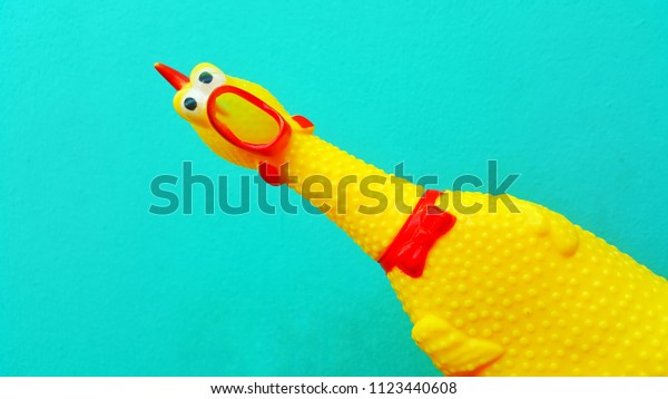 金切りの鶏鳴き玩具 青の背景におもちゃのゴムの金色の鶏 の写真素材 今すぐ編集