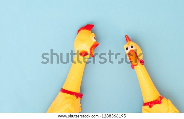 Shrilling\
Chicken toy on a blue background. Rubber squeaky Chicken Toys are\
isolated on a blue background.\
Copyspace