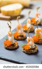 Shrimp Appetizer Served On Toasted Bread With Golden Caviar