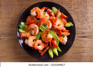 Shrimp, Avocado, Tomato And Cilantro Salad. Grilled Prawns On Black Plate. View From Above, Top Studio Shot