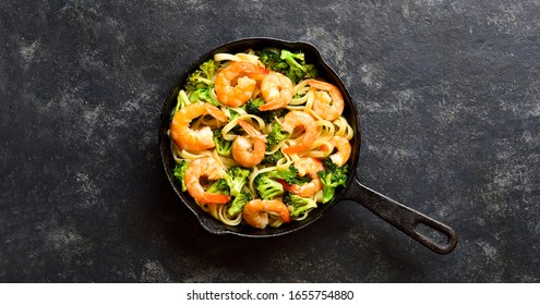Shrimp And Broccoli Pasta In Cast Iron Pan Over Dark Stone Background With Free Text Space. Tasty Healthy Dish For Dinner. Top View, Flat Lay