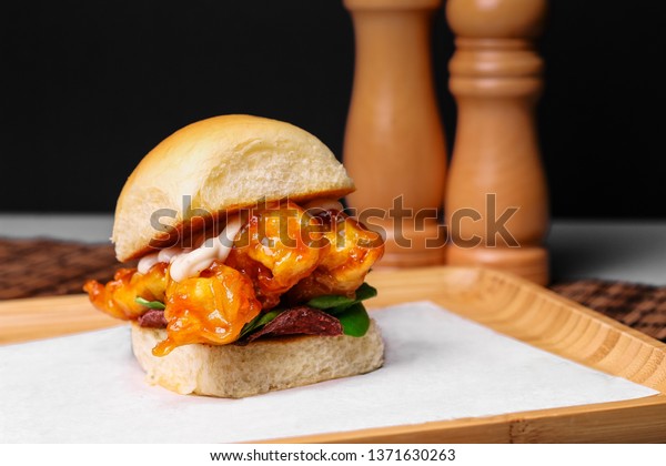 Shrimp burger on wooden
serving tray. Closeup slider burger with shrimp, spinach, beetroot,
sauce. - Image
