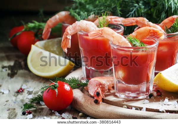 Shrimp cocktail in\
small glasses, cherry tomatoes, dill, parsley and lemon with salt\
and spices, selective\
focus