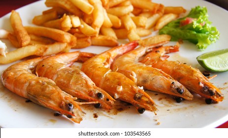 Shrimp. Fried Shrimp And Fried Potatoes With Salad On A White Plate. Dominican Cuisine