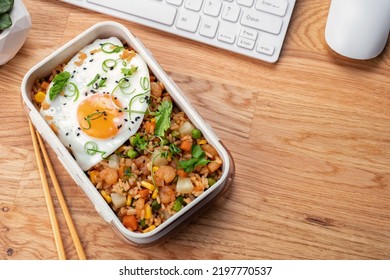 Shrimp fried rice with vegetables and fried egg in a lunch box - Powered by Shutterstock