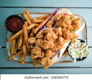 Shrimp Po'Boy sandwich with fries and coleslaw.