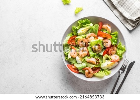 Shrimp Salad. Healthy Seafood Caesar Salad with prawns on white background, top view, copy space.