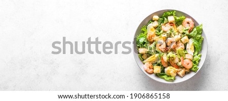 Shrimp Salad. Seafood Caesar Salad on white stone background, top view, copy space.