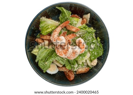 Shrimp Salad. Seafood Caesar Salad served with croutons, shrimps, salad leaf and parmesan on black background. Italian caesar salad.
Top view, copy space.