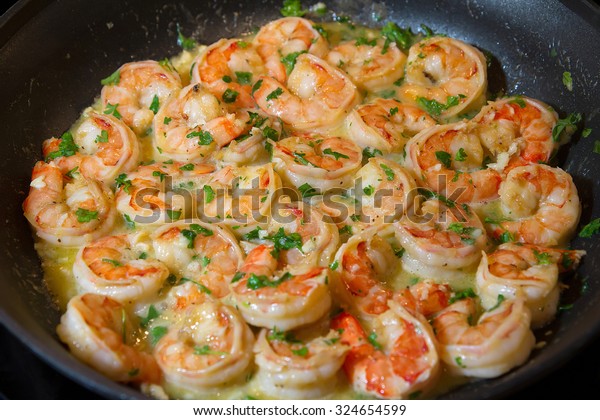 Shrimp scampi sauteed in butter and garlic with parsley\
sprinkled on top. 