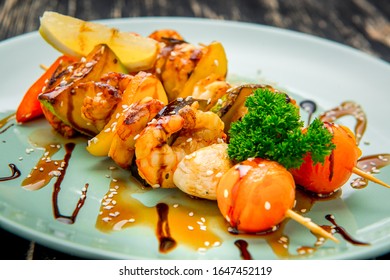 Shrimp And Vegetable Skewer On Grill Closeup. Against A Dark Background